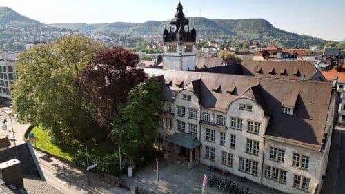 Campus view of Friedrich Schiller University Jena showing historic and modern academic buildings, green spaces, and student facilities.