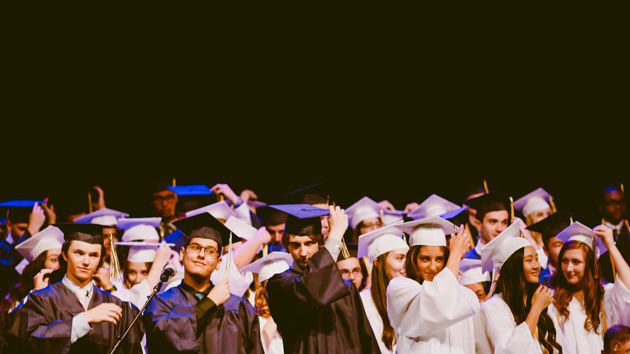 Graduates in black gowns and mortarboards at a university graduation ceremony