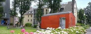 Main building of Wuppertal Church University, featuring traditional architecture and green spaces on the urban campus.